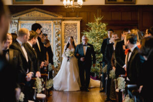 Bride walking down the aisle at Ramster Hall during a Christmas wedding venue celebration