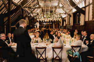 Oak-framed barn wedding venue dressed with candlelight and festive greenery for New Year’s Eve